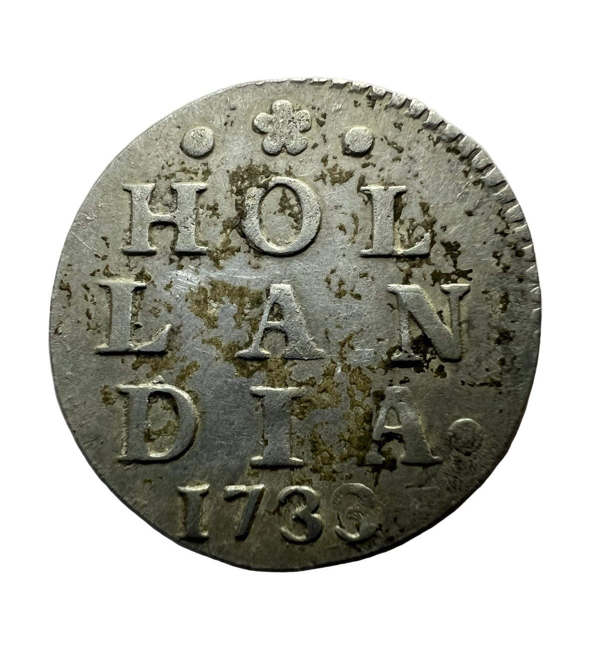 An antique circular silver coin featuring the text 'HOLLANDIA 1736' with a small crown emblem at the top.